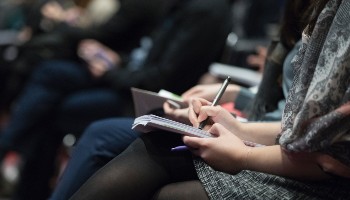 People taking notes at a conference