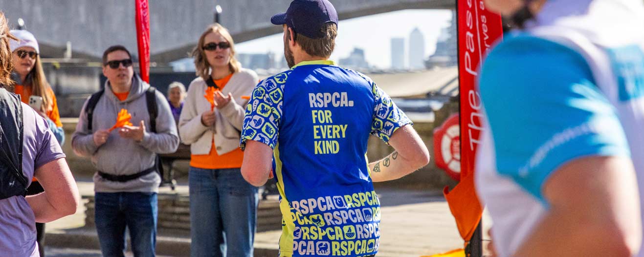 A charity runner wearing an RSPCA running top while running in London as part of an event.