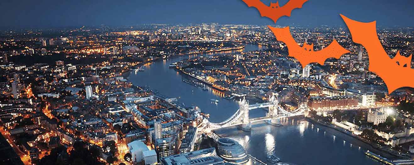 An aerial view of London at night over the Thames and London Bridge.