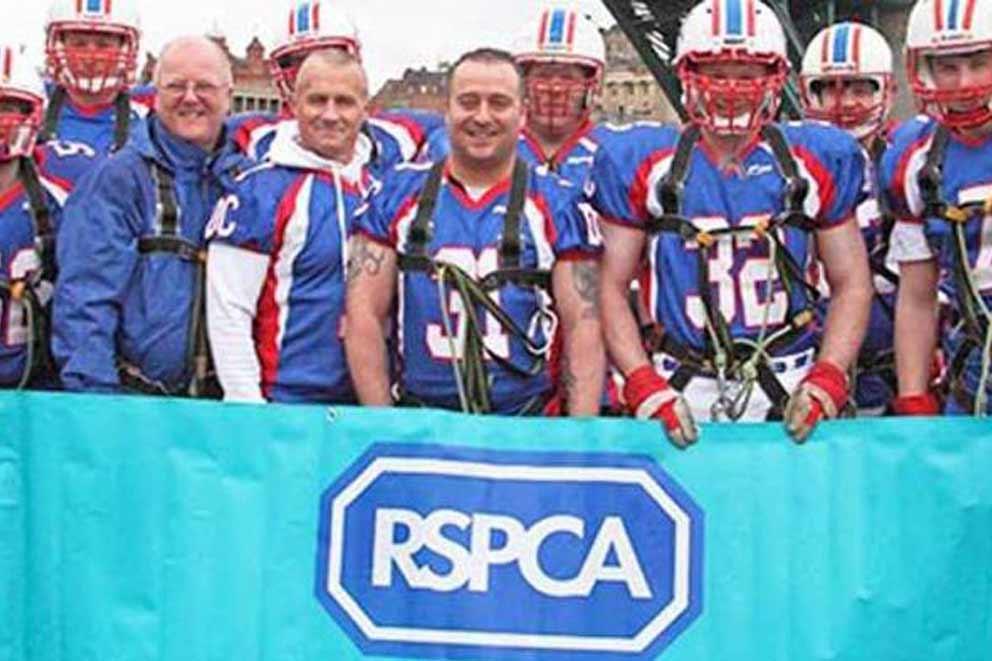 Charity fundraisers having completed activity holding up an RSPCA banner.