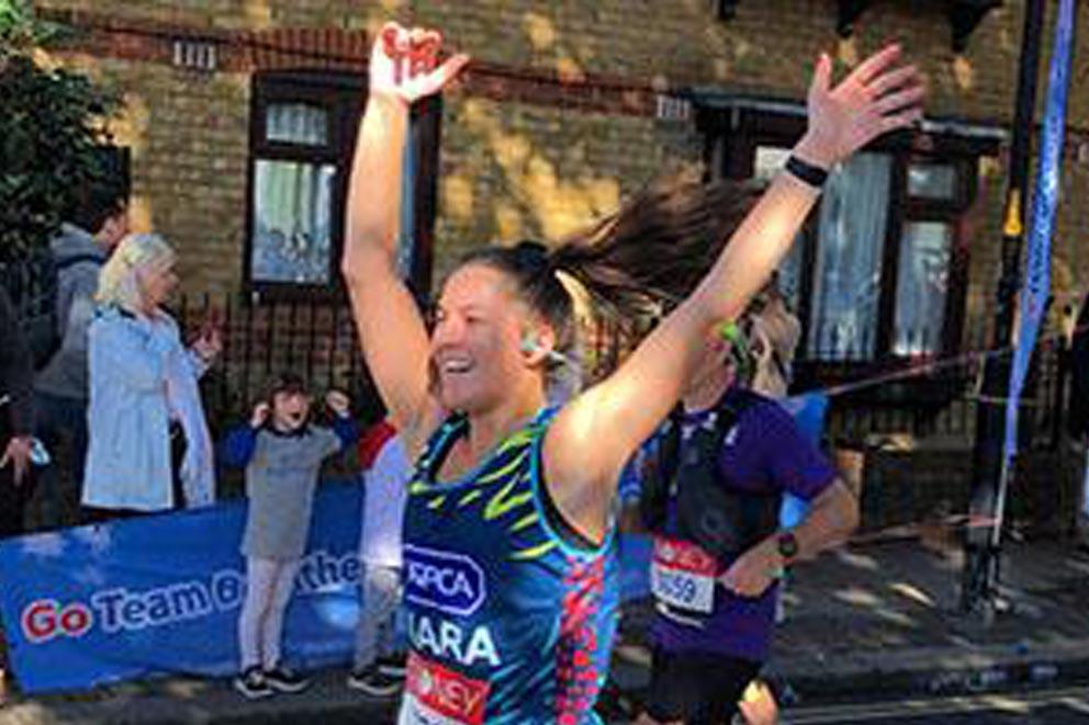 Finisher with hands in the air at an organised running event.