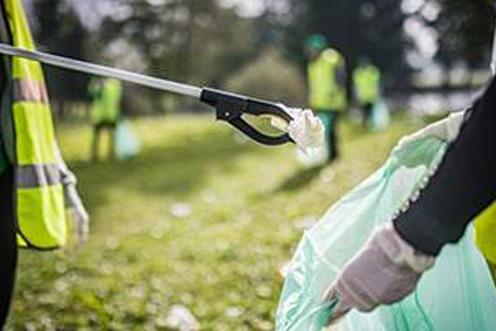 Litter picker placing trash in bag