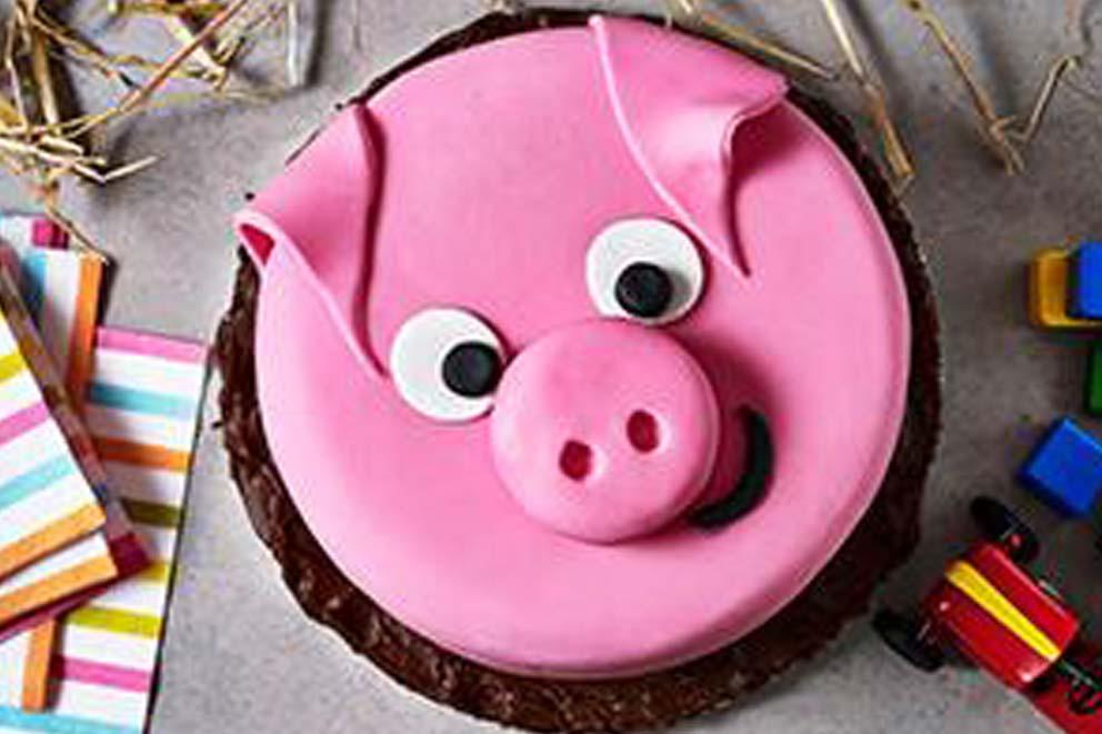 A pink iced pig themed birthday cake.