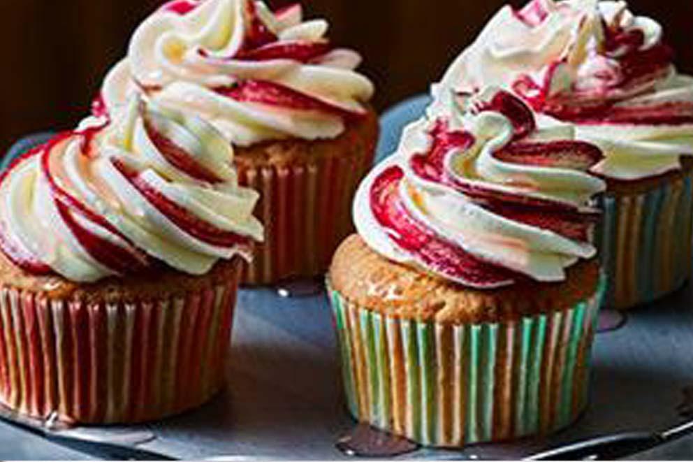 Four decorative cupcakes on a table.