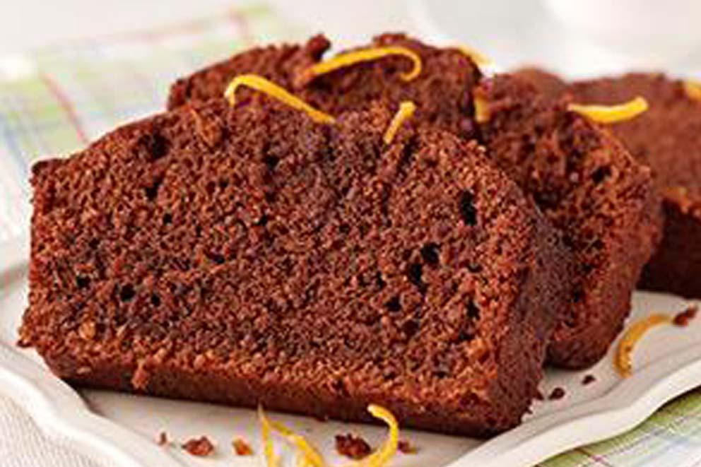 Three sliced pieces of sticky chocolate and orange cake ready to serve.